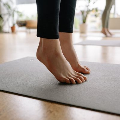 Close-up of feet on a yoga mat, showing balance.